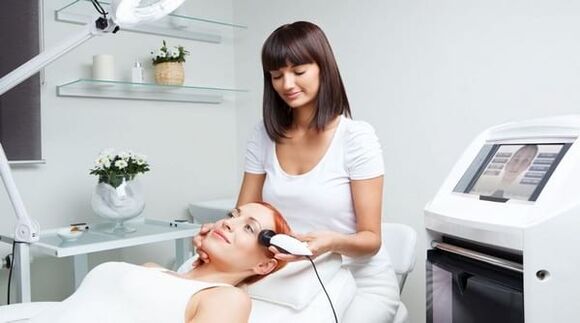 a specialist conducts a skin rejuvenation session with equipment